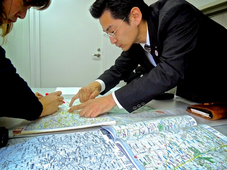 国際自動車ｋｍのタクシードライバーが雑誌「TOmagazine」の世田谷特集に取材を受け地図を使って説明